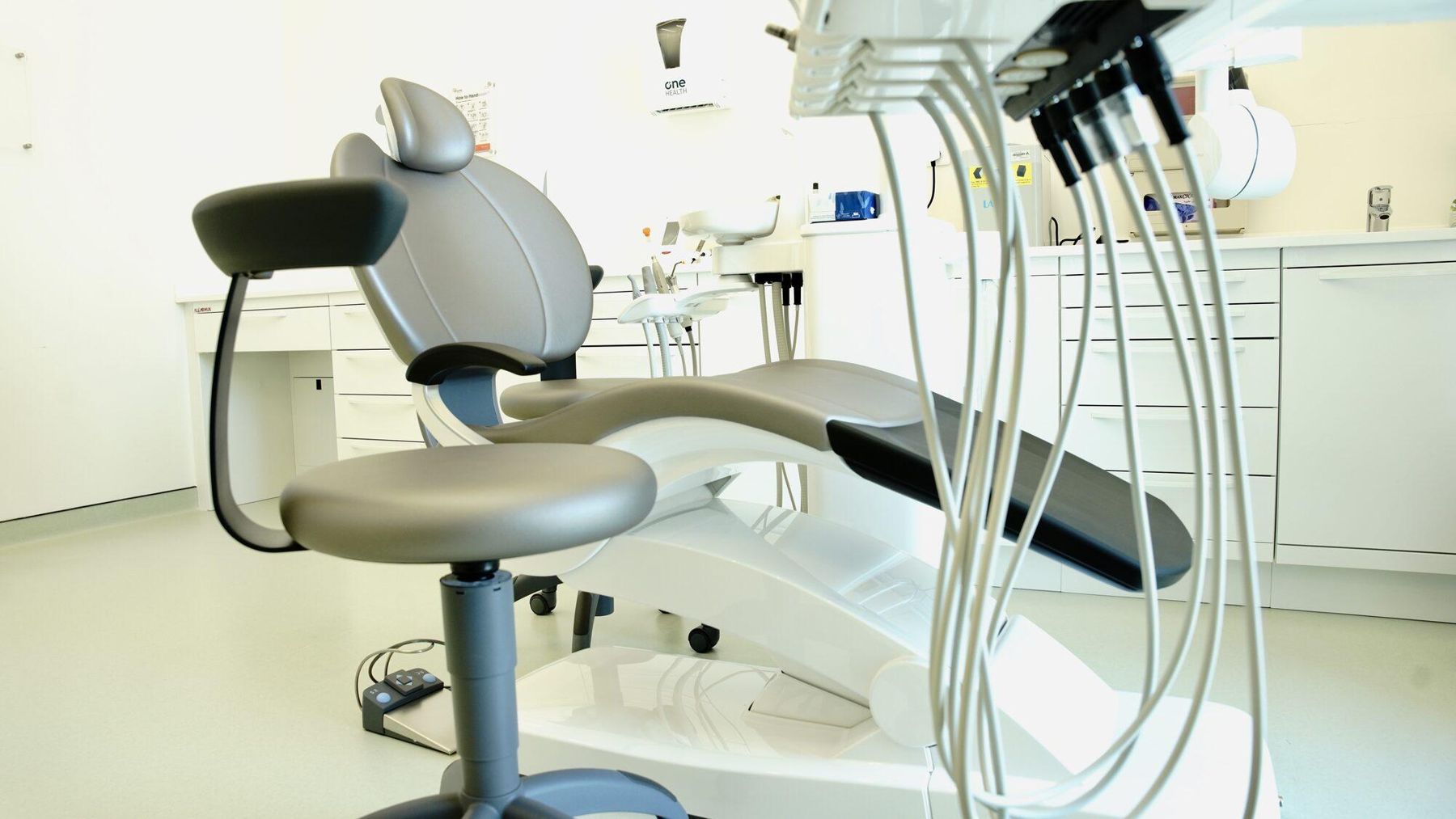 Modern dental chair and equipment in a white dental suite